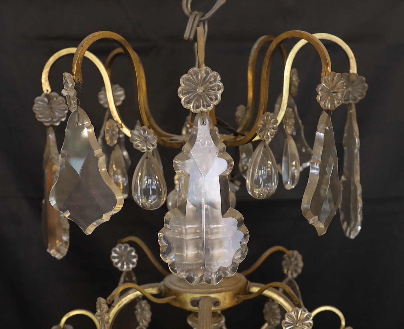 An early 20th century French bronze and cut glass twelve light chandelier, hung with tear, lozenge and flowerhead shaped drops, drop 114cm. width 72cm